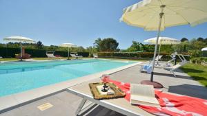 a pool with a table with an umbrella and chairs at Casa Il Pino in Cavriglia