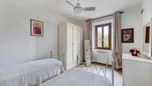 a bedroom with two beds and a window at Casa Il Pino in Cavriglia +21 photos