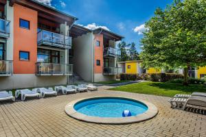 a courtyard with a swimming pool in front of a building at Velvet Lipno in Lipno nad Vltavou