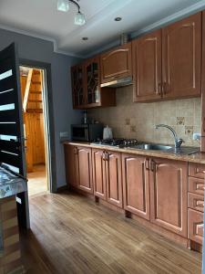 a kitchen with wooden cabinets and a sink at HOUSE Mold in Lazeshchyna +7 photos
