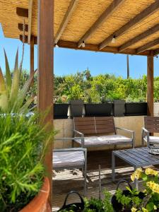 a patio with benches and tables on a deck at Seaside Serenity Kefalos in Kefalos