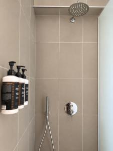 a bathroom with a shower with two bottles on the wall at Seaside Serenity Kefalos in Kefalos +22 photos