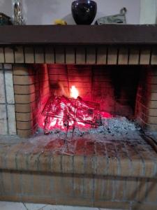 a red fire in a brick fireplace with a red at Christos House in Zárakes