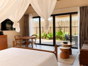 a bedroom with a bed and a living room at ENVI Paje Wellness Lodge in Paje