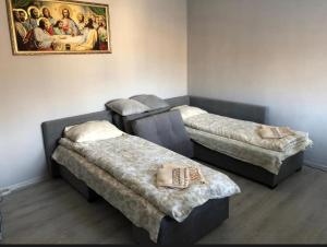 three beds in a room with a painting on the wall at HOUSE Mold in Lazeshchyna