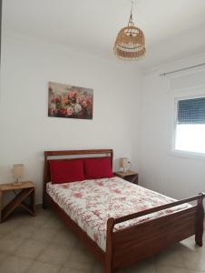 a bedroom with a bed and a painting on the wall at Appartement à oued laou mekkad in Oued Laou