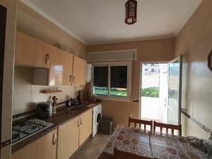 a kitchen with a table and a stove top oven at Appartement à oued laou mekkad in Oued Laou