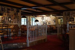 a restaurant with tables and chairs and pictures on the walls at Meadows Hotel in Perranzabuloe