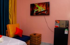 a room with a bed and a yellow chair and a picture at Magik Haven Studios Nyeri in Nyeri +2 photos