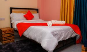 a bedroom with two beds with red and white sheets at Magik Haven Studios Nyeri in Nyeri