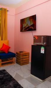 a living room with a tv on the wall and a chair at Magik Haven Studios Nyeri in Nyeri