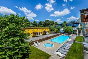 an overhead view of a pool with chairs and a building at Velvet Lipno in Lipno nad Vltavou