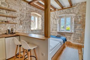 a small kitchen with a bed and two chairs at Stunning Views & Hidden Terraces Above the Old Town in Kotor