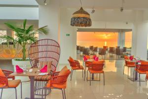 a restaurant with tables and chairs with pink items on them at King Evelthon Beach Hotel & Resort in Paphos