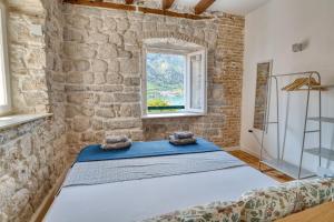 a bedroom with a bed in a brick wall at Stunning Views & Hidden Terraces Above the Old Town in Kotor
