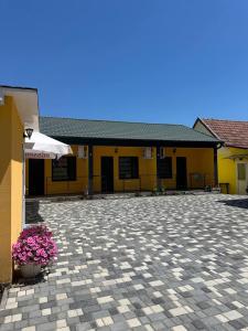 a yellow building with a patio with flowers and an umbrella at MANGO hotel in Zatoka