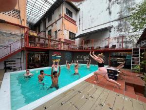 a group of people in a swimming pool at Chinatown Hostel by Mingle - Rooftop Private Jacuzzi with Bar in Kuala Lumpur
