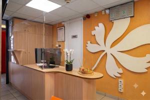an office with a reception desk with a flower on the wall at Premiere Classe Liege / Luik in Liège +15 photos