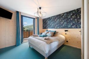 a bedroom with a bed and a large window at Lodge Six De Savoie in La Toussuire