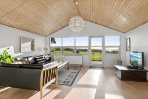 a living room with a couch and a tv at Rolsø Retreat - the apartment in Knebel