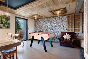 a room with a ping pong table and a stone wall at Lodge Six De Savoie in La Toussuire