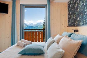 a bedroom with a bed with a large window at Lodge Six De Savoie in La Toussuire