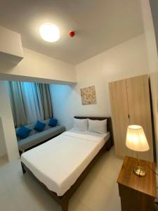a small bedroom with a bed and a couch at MyHappyPlace Elements in Manila