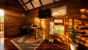 a room with a table and a television on a wall at Nalintara resort นลินธารารีสอร์ท in Ban Pha Saeng Lang
