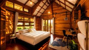 a bedroom with a bed in a wooden room at Nalintara resort นลินธารารีสอร์ท in Ban Pha Saeng Lang