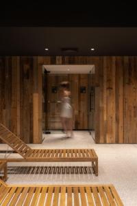 a person walking in a room with wooden walls at Runo Apartamenty & SPA - Basen Sauna - Odkryj-Białkę in Białka Tatrzańska