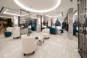 a salon with white chairs and tables in a building at Garden Melenium - Jazan in Jazan