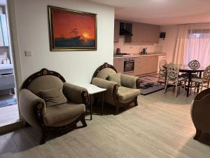 a living room with chairs and a table and a kitchen at Villa Tego in Çeşme