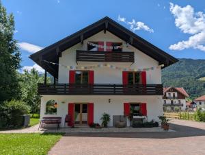 a white house with a black roof at Haus an der Kräuterwiese in Unterwössen