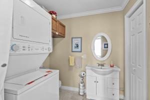 a white bathroom with a sink and a mirror at Westward Oceanfront Sunsets over Trinity Bay in Hearts Delight +20 photos