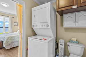 a small bathroom with a refrigerator and a toilet at Westward Oceanfront Sunsets over Trinity Bay in Hearts Delight