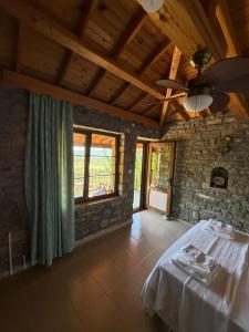 a room with a table and a stone wall at Vama Konuk Evi in Gokceada Town