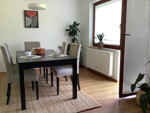 a dining room with a black table and chairs at Elly Apartment - 20 min to Ljubljana in Kresnice +4 photos
