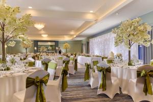 a banquet hall with white tables and chairs with bows at Actons Hotel Kinsale in Kinsale +23 photos
