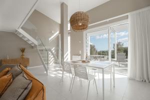 a white dining room with a table and chairs at Montegrottone Nature Retreat in Polignano a Mare