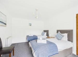 two beds in a room with white walls at Lagnakeil Highland Lodges in Oban