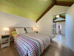 a bedroom with a bed with a colorful bedspread at Xola in Saint-Just-Ibarre