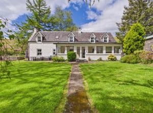 a large white house with a grass yard at Lagnakeil Highland Lodges in Oban