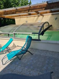 two chairs sitting next to a swimming pool at Gîte Aux Anges 51 in Thiéblemont-Farémont
