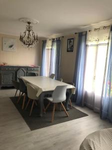 a dining room with a white table and chairs at Gîte Aux Anges 51 in Thiéblemont-Farémont