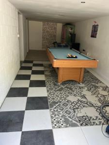 a pool table in a room with a checkered floor at Gîte Aux Anges 51 in Thiéblemont-Farémont +12 photos