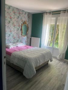 a bedroom with a bed with pink sheets and floral wallpaper at Gîte Aux Anges 51 in Thiéblemont-Farémont
