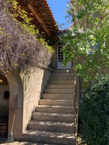 a staircase leading up to a house with a white door at Manor House Dungeon in Chozendo