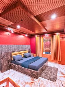 a bedroom with a large bed in a red room at Being Himalayan Chojh in Manīkaran