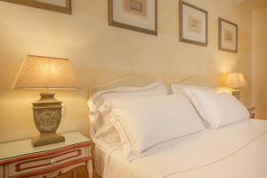 a bed with white sheets and a lamp on a table at Hotel Rivalago in Sulzano