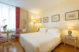 a bedroom with a large white bed and a desk at Hotel Rivalago in Sulzano